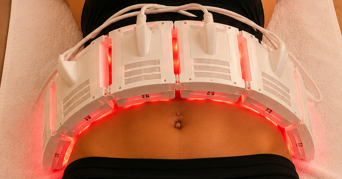 InvisaRED red light body contouring pads in contact with a patient's midsection during a session at Total Wellness Chiropractic in Bowie, MD